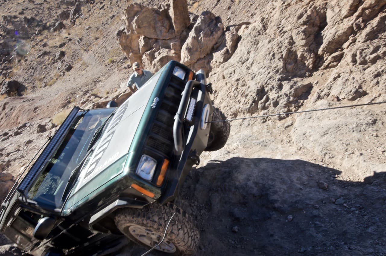 Jeep Cherokee getting winched up a ledge on Doran trail near Calico