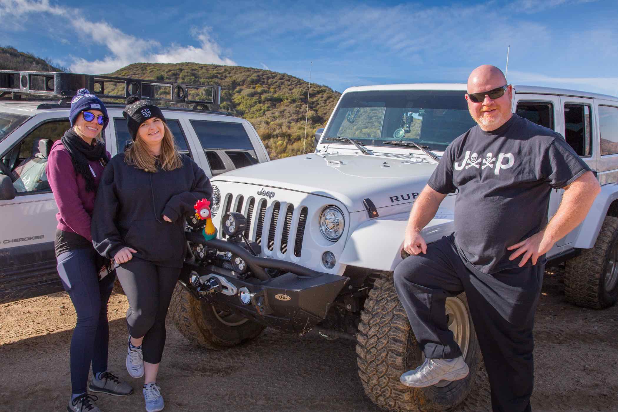 Jeepers doing a Captain Morgan pose on their Jeep