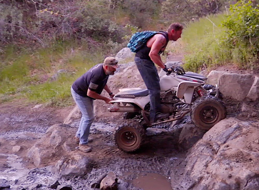 Keven Kelly, co-founder of Combat Crawlers helping a quad-rider up the trail in Los Pinos Peak in the Corral Canyon OHV area of Southern California.